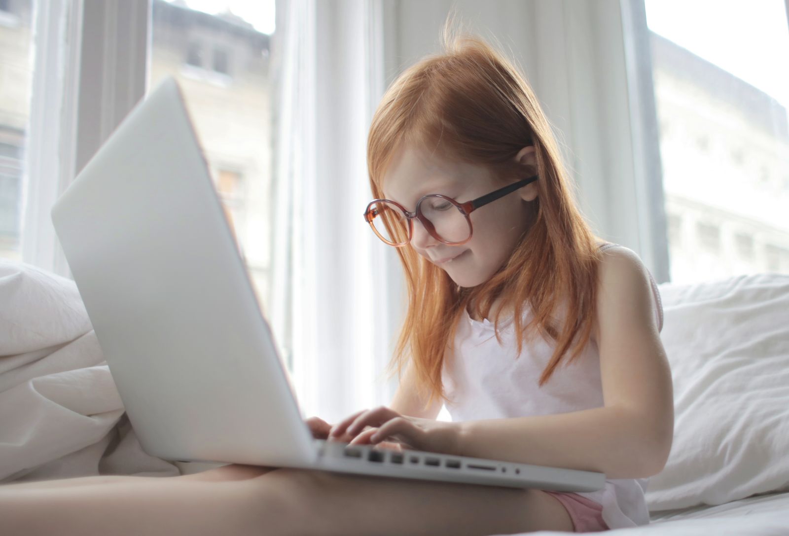 A young student working excitedly on a laptop